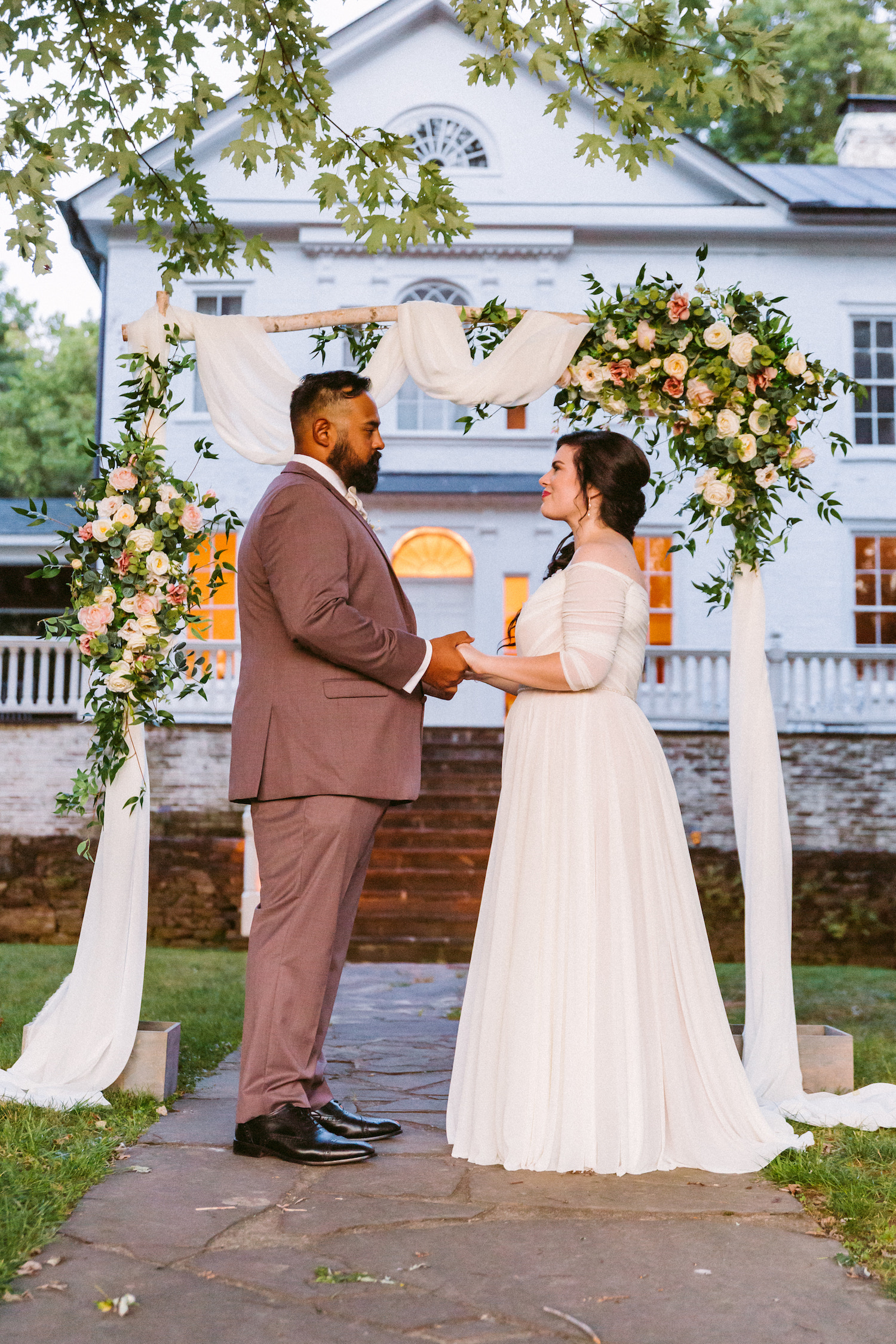 Bride and groom hold hands while standing at the altar during their wedding at a Virginia mountain wedding venue. Photo by luxury wedding photographer Victoria Heer.