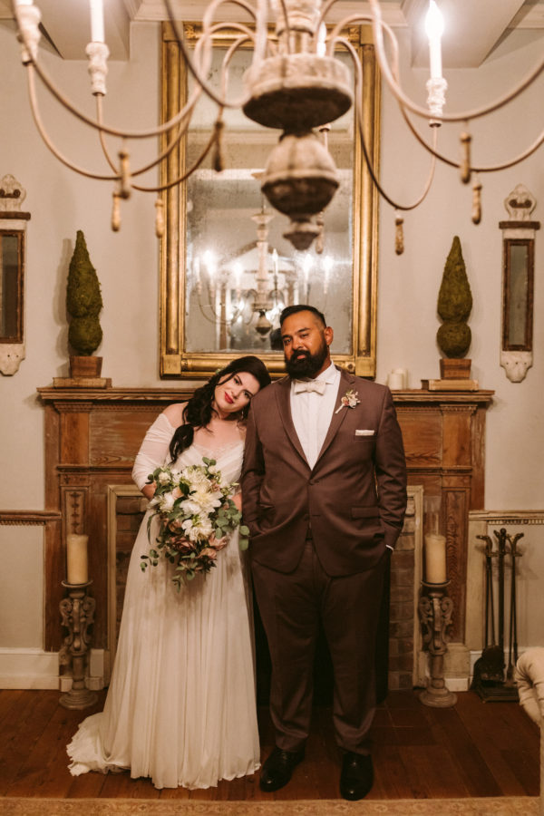 A bride and groom pose in front of the fire place at The Retreat at Cool Spring, which is one of the Virginia mountain wedding venues. Image by Victoria Heer, Washington DC wedding photographer.
